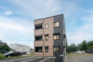 een hoog houten gebouw met ramen op een parkeerplaats bij MKS201 - Vacation STAY 20134 in Gojōdōri