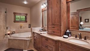 a bathroom with two sinks and a tub and a large mirror at Chalet Fuego in Steamboat Springs