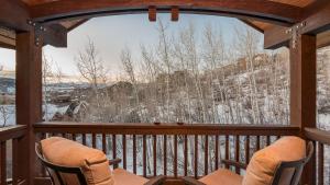 a screened in porch with two chairs and a large window at Chalet Fuego in Steamboat Springs +19 photos