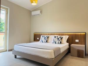 a bedroom with a large bed with blue and white pillows at Villa Paglianiti - Your FAMILY Residence! in Briatico