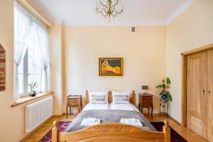 a bedroom with a large bed and a chandelier at Cosmo - Old Money Apartment in Gdańsk