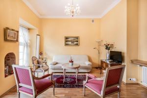 a living room with a couch and a table and chairs at Cosmo - Old Money Apartment in Gdańsk