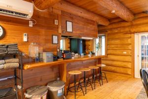 un bar en una cabaña con paredes y taburetes de madera en Log Base Kurohone no oka - Vacation STAY 38674v, en Miyozawa