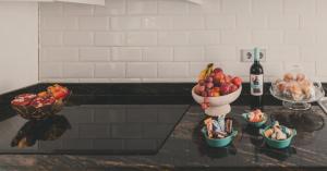 a counter with a bowl of fruit and a bottle of wine at City Deluxe Apartment in Madrid