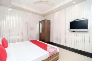 Un dormitorio con una cama y un televisor de pantalla plana. en Hotel O Le Bon Ton, en Ludhiana 20 fotos más