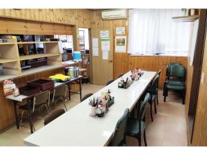 a classroom with long tables and chairs in a room at Hotel Park Light - Vacation STAY 39486v in Inai