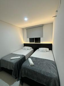 a room with two beds with towels on them at Central Suite in Cúcuta +22 photos