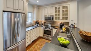a kitchen with white cabinets and a stainless steel refrigerator at Chalet Verve in Beaver Creek