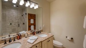 a bathroom with two sinks and a toilet and a mirror at Chalet Verve in Beaver Creek +22 photos