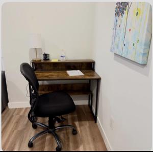 a desk with a black chair in a room at Homey Basement Suite by Gaudi in Calgary