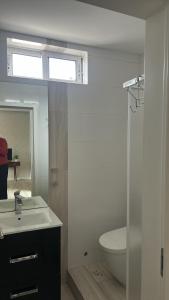 a bathroom with a sink and a toilet and a window at Bragaterrace in Braga
