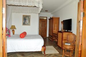a bedroom with a bed and a flat screen tv at Fort Fun City Hotel Fort Portal in Fort Portal