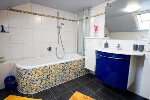 a bathroom with a tub and a sink at Gemütliche DG-Wohnung mit großer Küche & Parkplatz in Burglengenfeld +11 photos