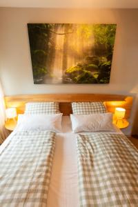 two beds in a bedroom with a painting on the wall at Gemütliche DG-Wohnung mit großer Küche & Parkplatz in Burglengenfeld