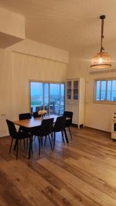 a dining room with a table and chairs with a view at צימר החורש in Dāliyat el Karmil