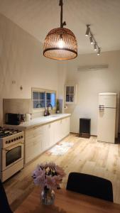 a large kitchen with a table and aendant light at צימר החורש in Dāliyat el Karmil