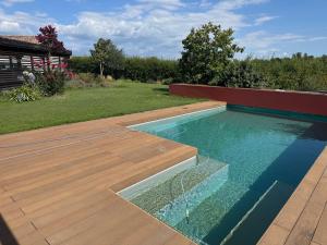 a swimming pool in a yard with a wooden deck at Chambre Léandre in Montauban