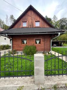 a wooden house with a fence in front of it at Chata u Ondríka in Čierny Blh