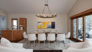 a dining room with a table and white chairs at Creekside Chalet in Steamboat Springs