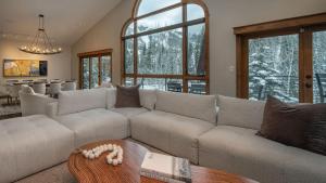 a living room with a white couch and a table at Creekside Chalet in Steamboat Springs