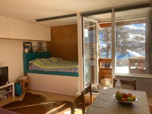 a bedroom with a bed and a table with a bowl of fruit at Studio Vars in Collobrières