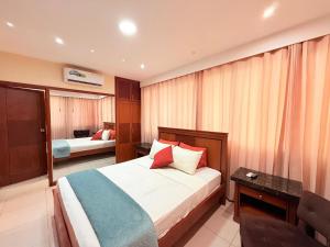 a hotel room with a bed and a mirror at Departamento de 2 habitaciones, 2 camas, 1 baño in Machala