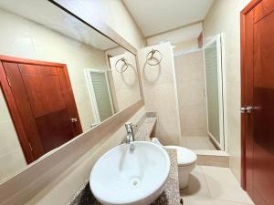 a bathroom with a sink and a toilet and a mirror at Departamento de 2 habitaciones, 2 camas, 1 baño in Machala +11 photos