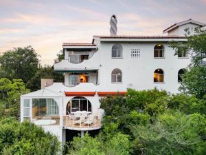 a white house with a wrap around porch at La Casa Blanca in Johannesburg