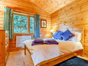a bedroom with a bed in a log cabin at 2 Bed in Blandford Forum 61027 in Child Okeford