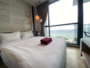 a large white bed with a red bag on it at Stunning Sea View Condo -Next To Beach in Pattaya South +57 photos