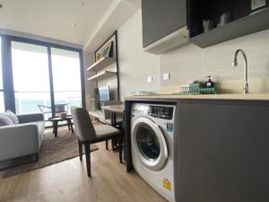 a kitchen with a washing machine in a living room at Stunning Sea View Condo -Next To Beach in Pattaya South