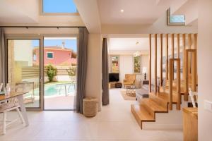 a living room with a view of a house at Villa Daphne Gouvia by Villa Plus in Gouvia