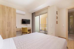 a bedroom with a white bed and a desk at Villa Daphne Gouvia by Villa Plus in Gouvia +19 photos