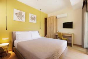 a bedroom with a bed and a desk and a television at Villa Daphne Gouvia by Villa Plus in Gouvia