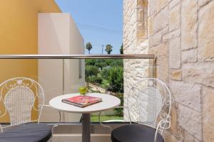 a table and chairs on a balcony with a window at Villa Daphne Gouvia by Villa Plus in Gouvia