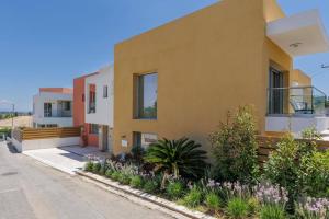 a house in the suburbs with plants and flowers at Villa Daphne Gouvia by Villa Plus in Gouvia