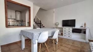 a dining room with a table and chairs and a television at Villaparadisi in Benicàssim