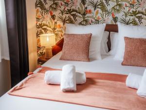 a bedroom with a bed with towels on it at Ocalie, Charme et Plage à Deux Pas in Les Trois-Îlets