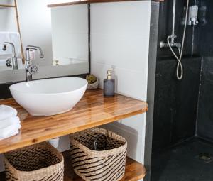 a bathroom with a sink and a counter with baskets at Ocalie, Charme et Plage à Deux Pas in Les Trois-Îlets +14 photos