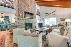 a living room with couches and a brick fireplace at Chic Highlands Cabin Retreat with Deck and Office! in Highlands