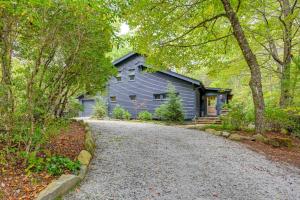 a blue house with a driveway in front of it at Chic Highlands Cabin Retreat with Deck and Office! in Highlands