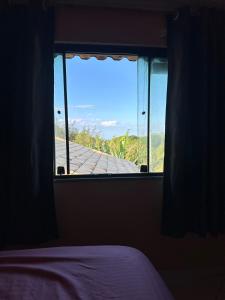 a room with a window with a bed and a view at Kitnet Pontal Beach in Arraial do Cabo
