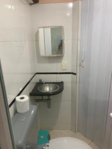 a small bathroom with a sink and a toilet at Kitnet Pontal Beach in Arraial do Cabo +24 photos