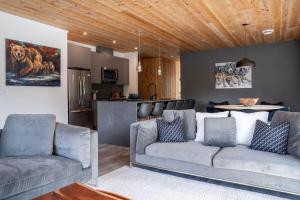 a living room with a couch and a kitchen at The Begbie Penthouse in Mackenzie Village in Revelstoke