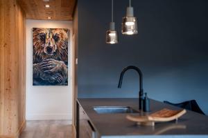 a kitchen with a painting of a tiger on the wall at The Begbie Penthouse in Mackenzie Village in Revelstoke +36 photos