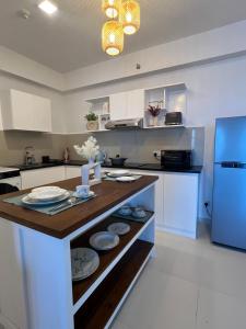 a kitchen with white cabinets and a blue refrigerator at Sandora Living in Wattala