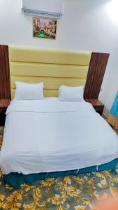 a large white bed in a room with a yellow wall at منتجع سيتي لاند فله رقم 4 in Taif