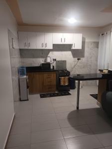 a kitchen with white cabinets and a table in it at 1 bedroom BNB Meru in Meru