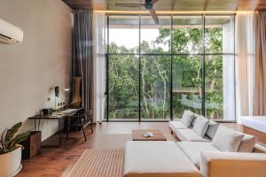 a living room with a white couch and a large window at Piece Lio from Japan Managed by H Hospitality Group in El Nido +184 photos