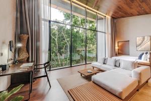 a living room with a couch and a large window at Piece Lio from Japan Managed by H Hospitality Group in El Nido